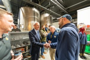 Broken Bat Brewing Co Owner and 2010 Marquette alumni Tim Pauly shakes hands with University President Dr. Michael Lovell